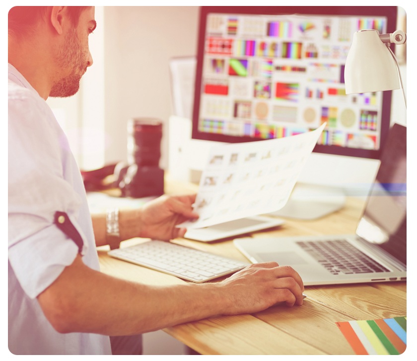 man at desk looking at printout